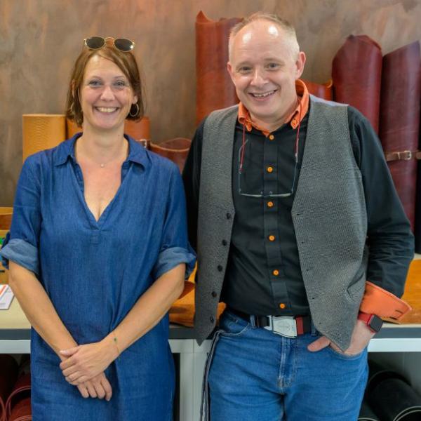 Eine Frau und ein Mann stehen vor einem Tisch auf dem sich große Lederrollen befinden | Foto: Walter Schernstein