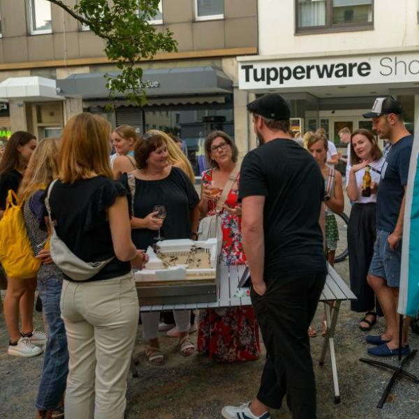 Einige Bürger*innen schauen sich die Planung des Rathausmarktplatzes auf einem Plakat an und lassen sich den Entwurf erläutern. | Foto: Walter Schernstein