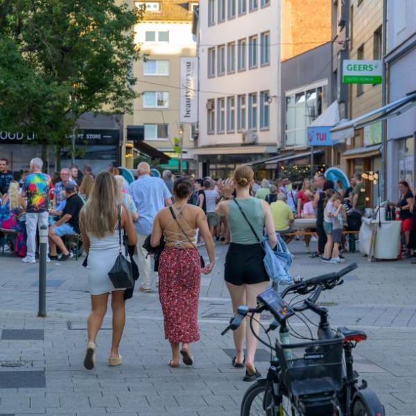 Passanten halten sich auf einer mit hellblauen Fahnen geschmückten Straße auf | Foto: Walter Schernstein